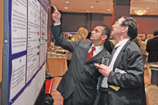 Two attendees peruse a poster at Digestive Disease Week