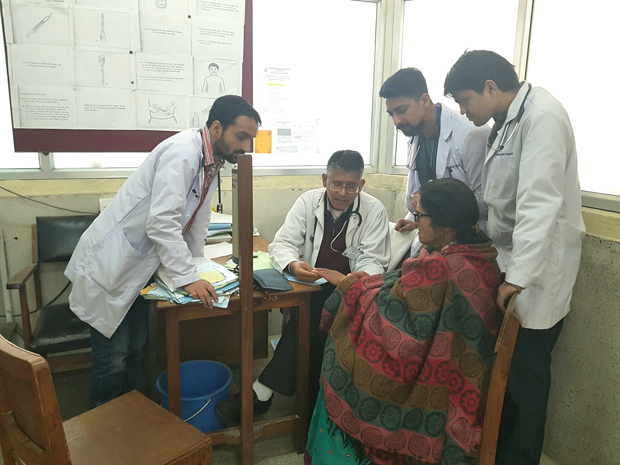 In the outpatient department of Patan Hospital in Kathmandu Nepal professor of medicine Buddhi Paudyal MD center seated explains the finer points of a patients rheumatoid arthritis to three ne